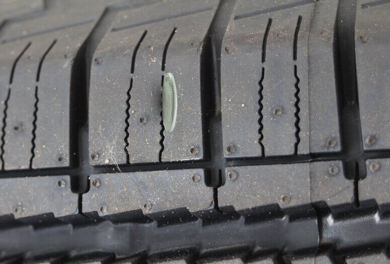A coin inserted in a the tire tread