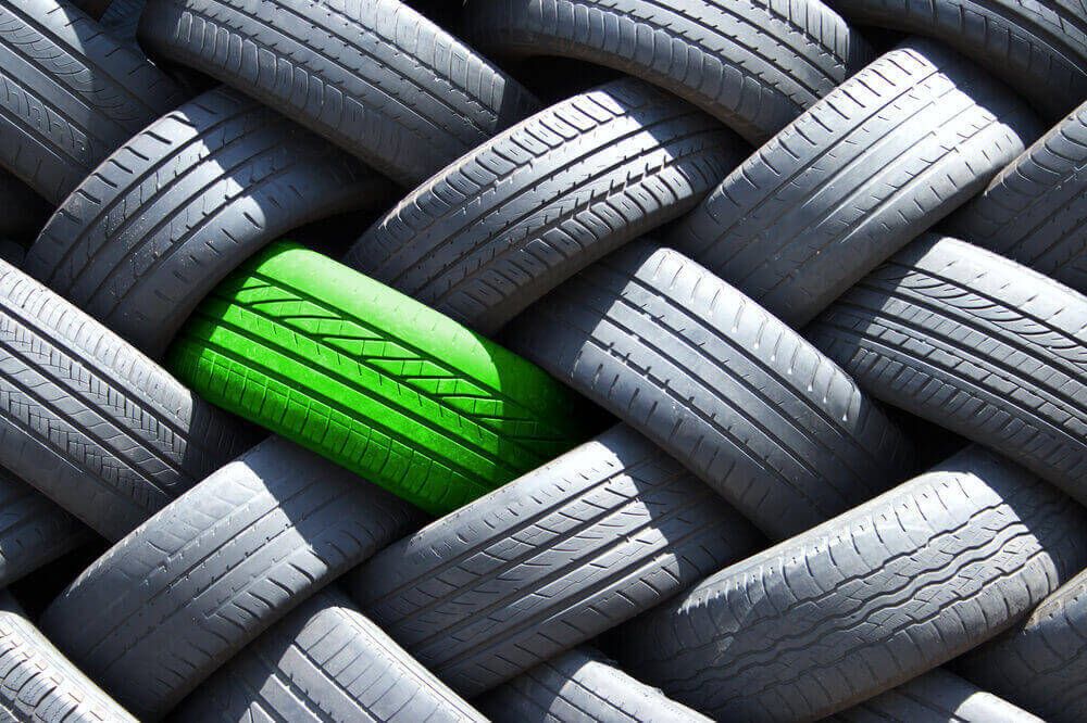Un pneu vert écologique parmi un grand inventaire de pneus