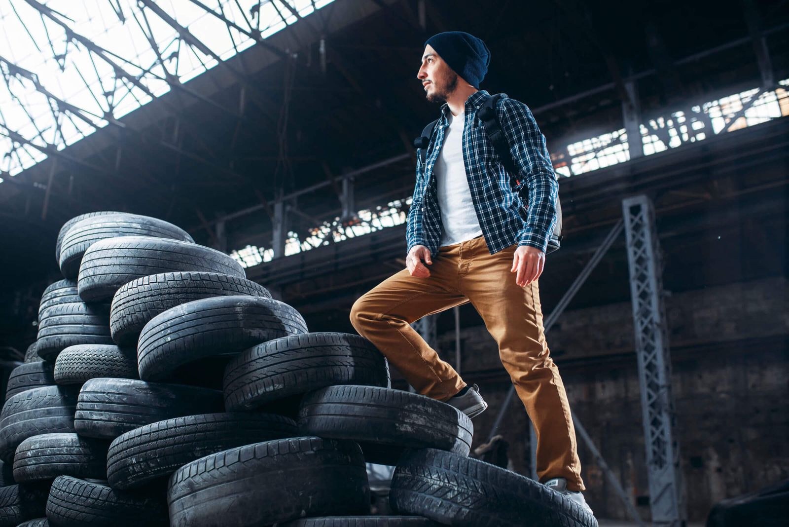 Stalker, traveler climbs a mountain of tires