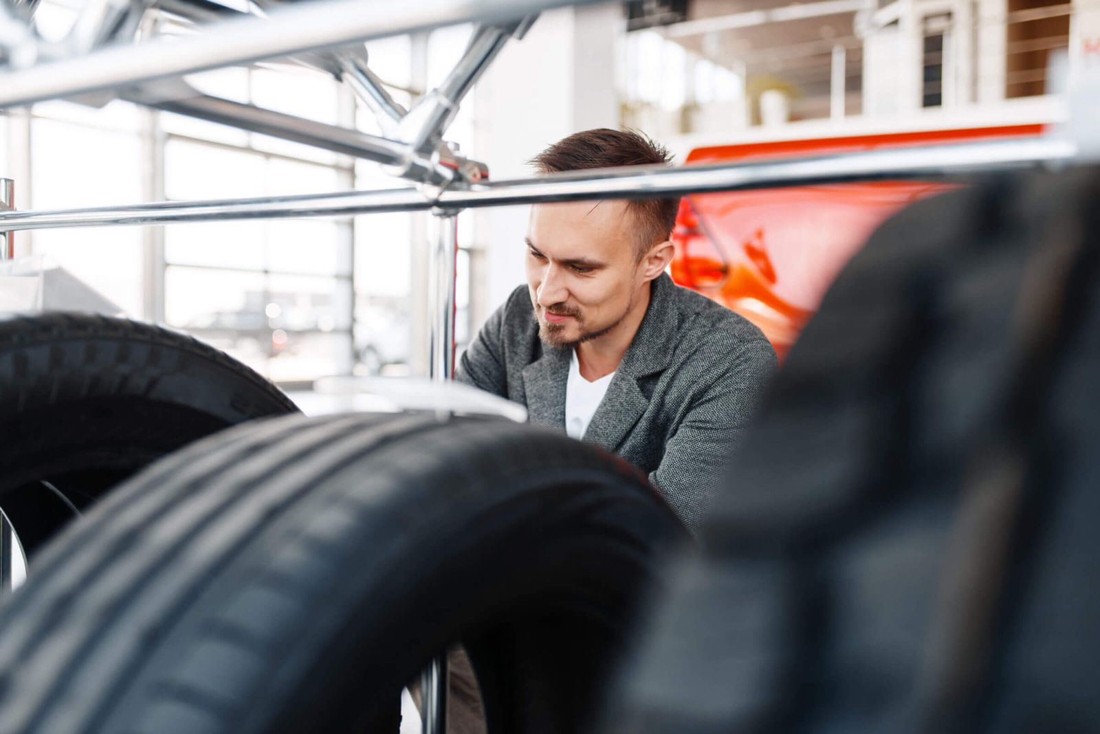 Man chooses tires for a new car in the showroom