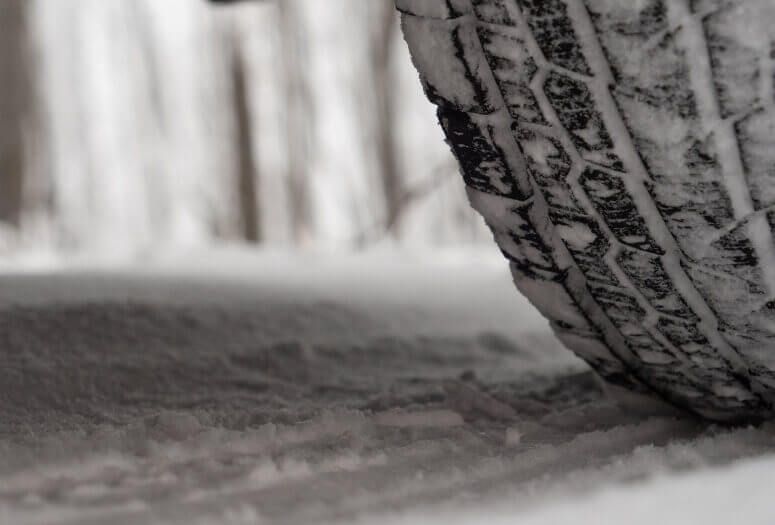 Close-up of a winter tire driving safely on snow