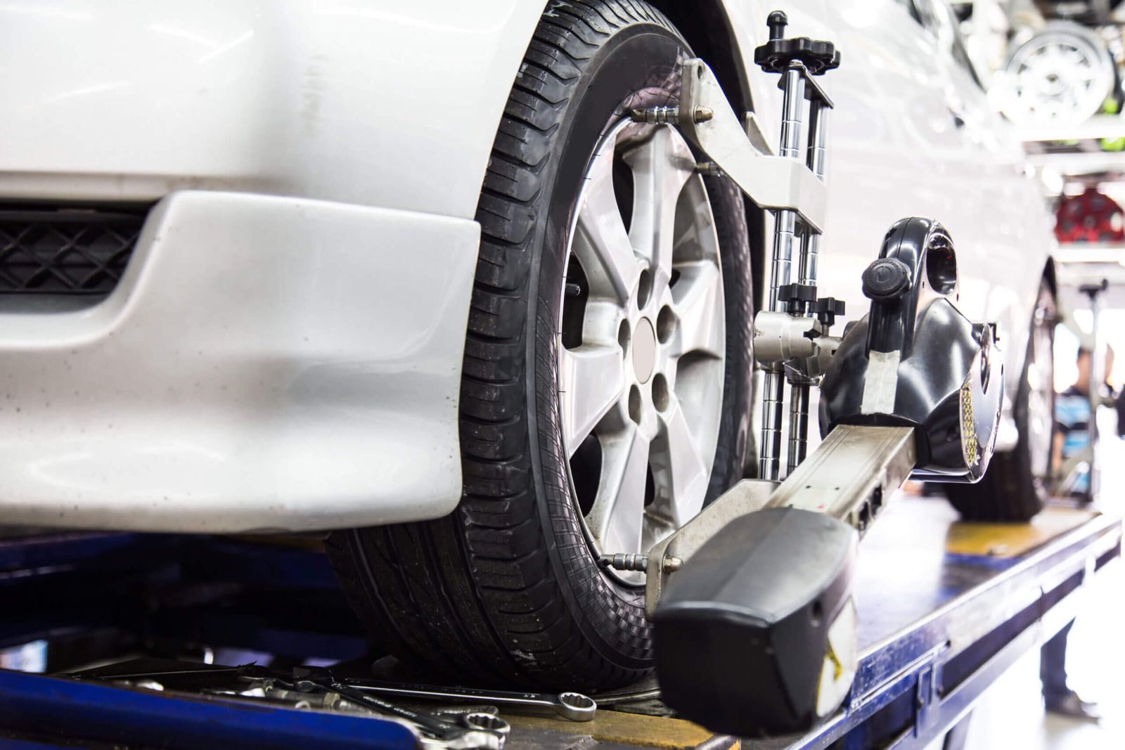 Close up of a tire tight with aligner undergoing automatic wheel alignment in a garage