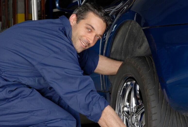 A mechanic prepares to align the wheel of a car