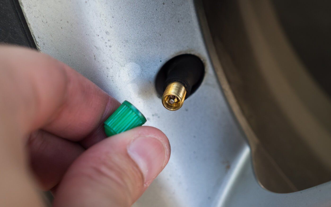 Hand placing the cap on the nitrogen tire valve