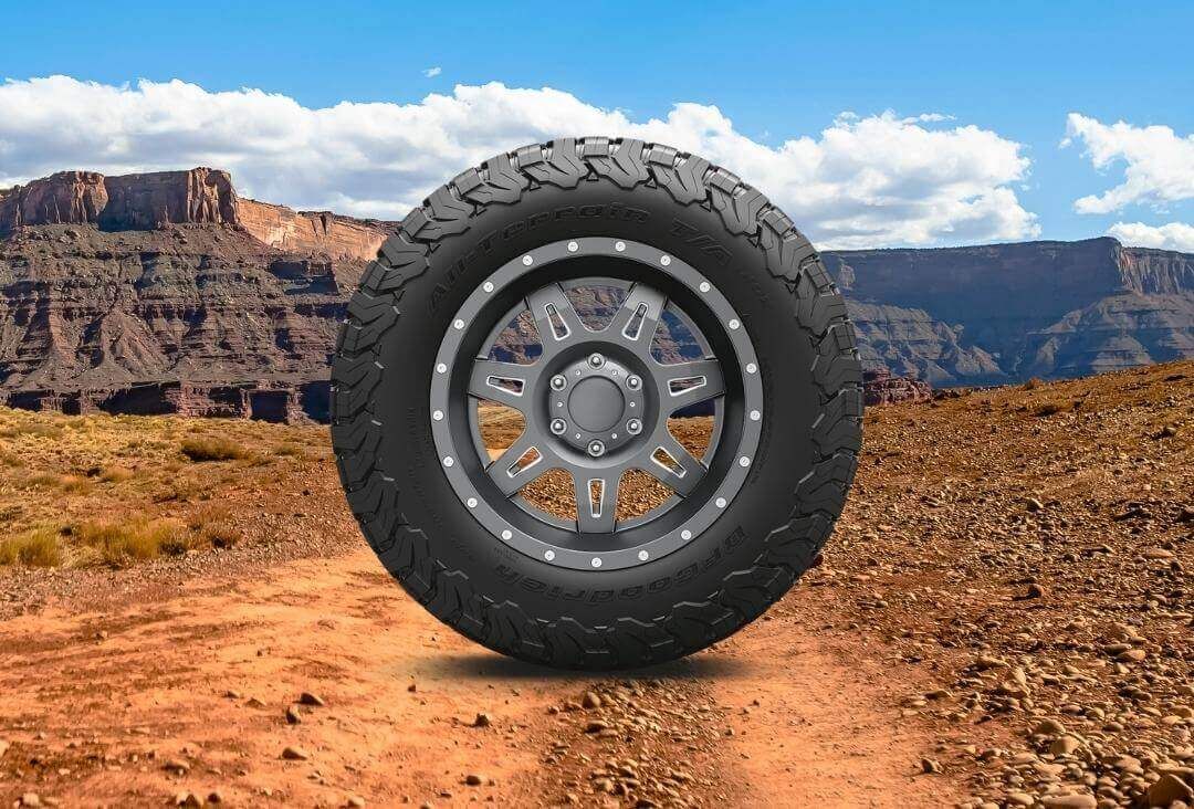 Large bfgoodrich all-terrain KO2 tire on an off-road landscape background